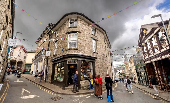 People walking around a town full of book shops and independent stores.